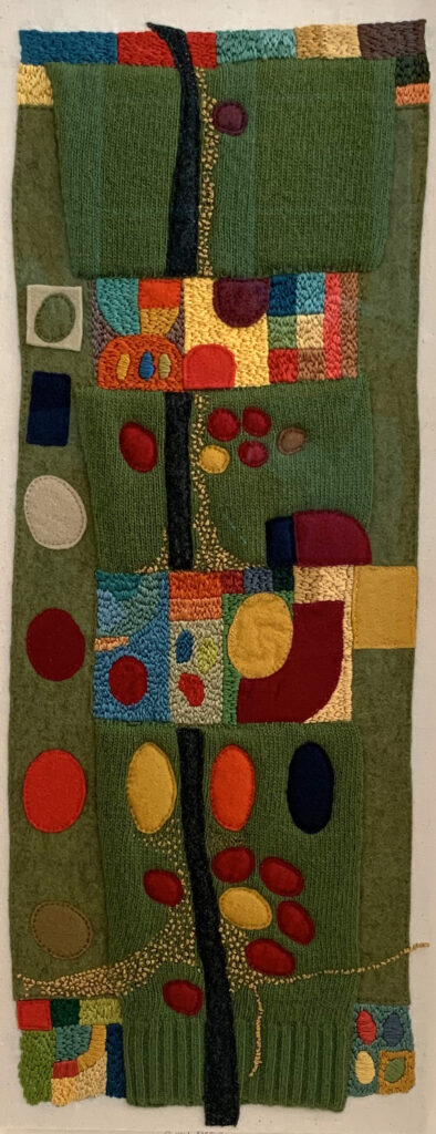 Greensleeves. image showing showing the sleeve from a green jumper embroidered in multicoloured shapes 