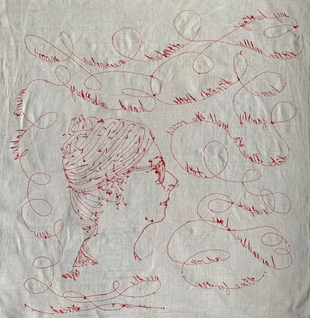 Hand embroidered red thread in couching stitch.