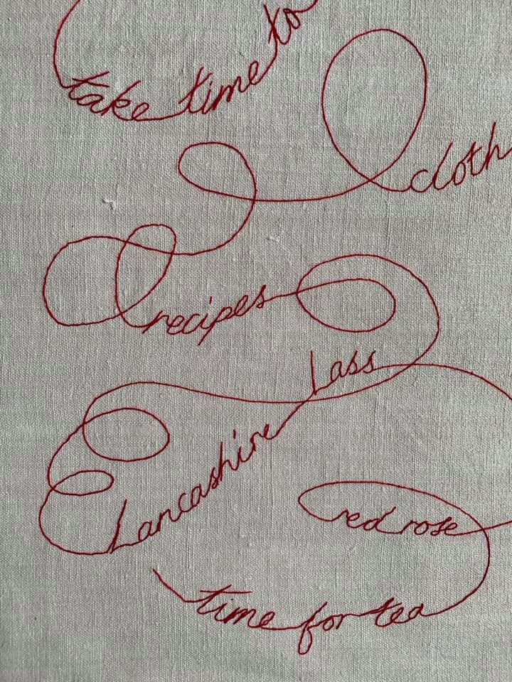 Detail: Hand embroidered red thread in couching stitch.