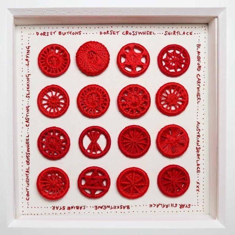 A collection of red handmade dorset buttons stitched onto a panel with hand embroidered words around the edge stating the names of the different types of dorset buttons. All made in red thread.