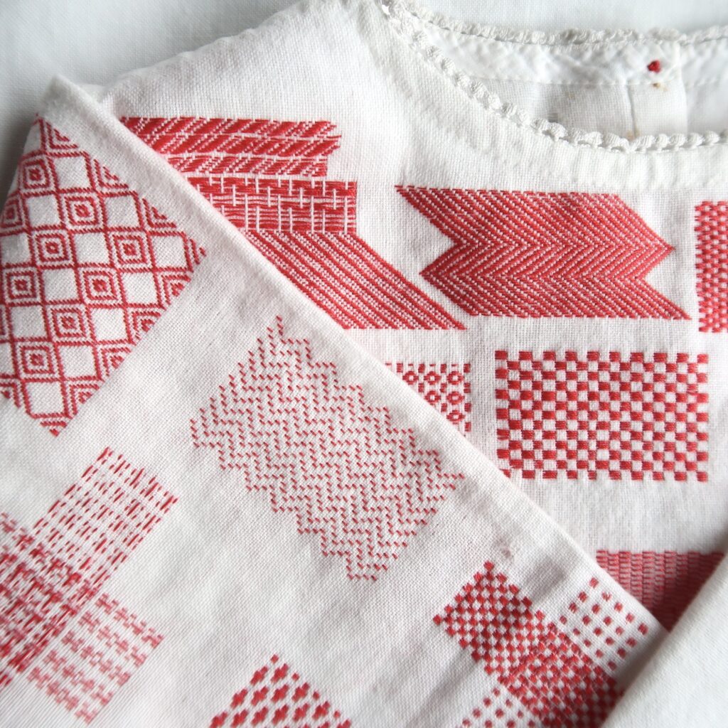 Darning Sampler - hand stitched red thread into a vintage white child's garment