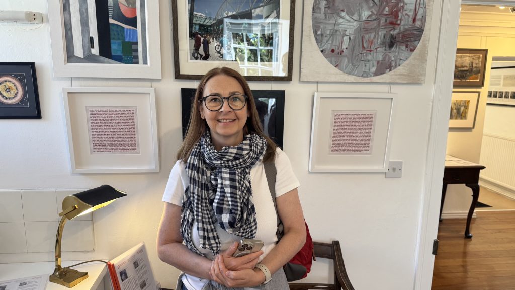 Catherine and her hand embroidered artwork on display within the venue